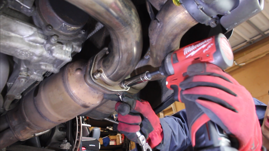 Remove center muffler exhaust flange nuts (3 on each side)