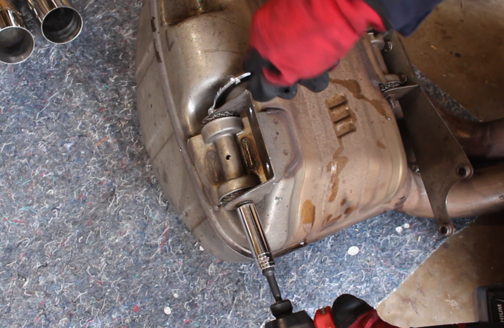 Transfer the muffler support brackets from the original mufflers to the ECG Performance mufflers.